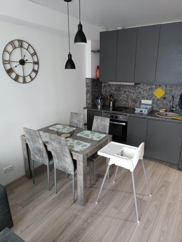 a kitchen with a table and chairs and a clock at Bruklinas in Šiauliai