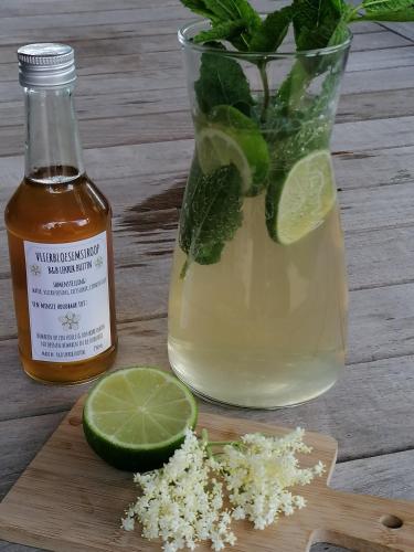 a vase of lime and a jar of honey and lime slices at B&B Lekker Buiten in Stratendries
