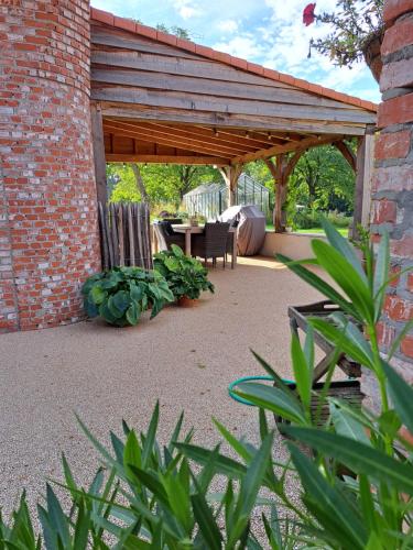 a patio with a wooden pavilion with a table and chairs at B&B Lekker Buiten in Stratendries