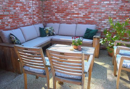 a patio with a couch and a table and chairs at B&B Lekker Buiten in Stratendries