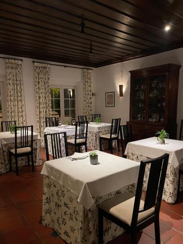 a dining room with tables and chairs with white tablecloths at Hotel Rural Monte da Provença in Elvas