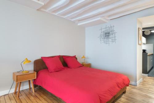 - une chambre avec un lit rouge et du parquet dans l'établissement LOVELY FLAT IN MONTORGUEIL PARIS, à Paris