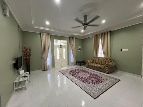 a living room with a couch and a ceiling fan at Relaxs Homestay in Kota Bharu