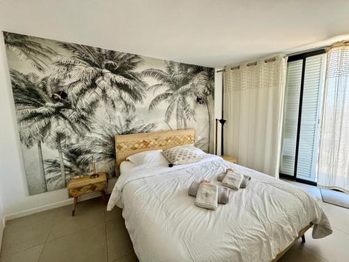- une chambre avec un lit et du papier peint en palmier dans l'établissement Le Sunrise - panorama sur l'estuaire, à Royan