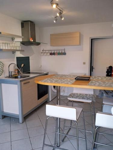 une cuisine avec un comptoir, une table et des chaises dans l'établissement Maisonnette en Val de Loire, à Messas