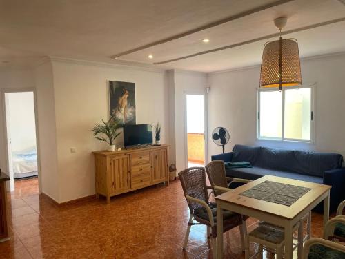 a living room with a blue couch and a table at San juan 2 bedrooms 27 in Playa de San Juan