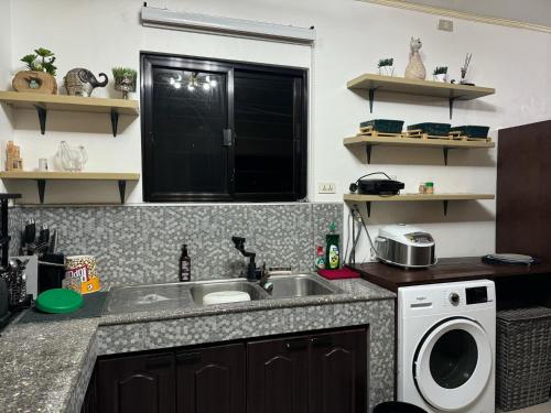 a kitchen with a sink and a washing machine at MDEC Apartments in Hilongos
