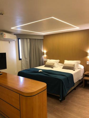 a bedroom with a bed with a desk and a tv at Fortaleza 703--Fortaleza 713 in Fortaleza
