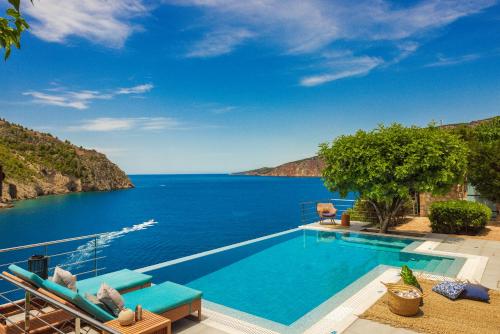 a swimming pool with a view of the ocean at Braunis Horio Villas in Asos
