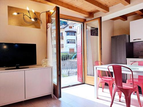 una cucina con tavolo, sedie e televisione di La Casa di Allegra a Vione
