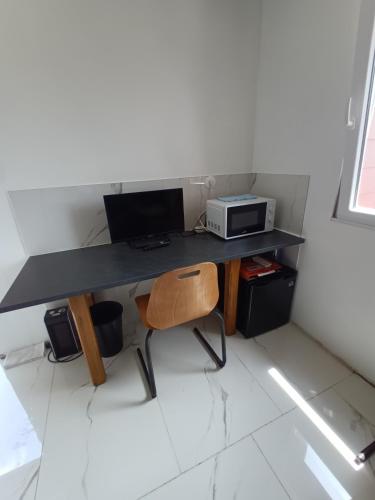 Cette chambre comprend un bureau avec un ordinateur et une chaise. dans l'établissement Soleil levant au domaine de Tara, à LʼHôpital-du-Grosbois