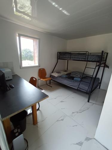 Cette chambre comprend un bureau et des lits superposés. dans l'établissement Soleil levant au domaine de Tara, à LʼHôpital-du-Grosbois