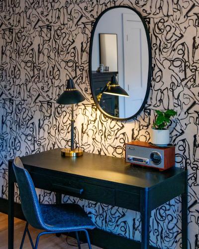 a desk with a mirror and a table with a chair at Twin Gables of Woodstock in Woodstock