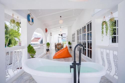 a bath tub in a white bathroom with plants at Your Sea Cret pool villa in Jomtien Beach