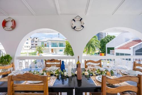a dining room with a table and chairs and a clock at Your Sea Cret pool villa in Jomtien Beach