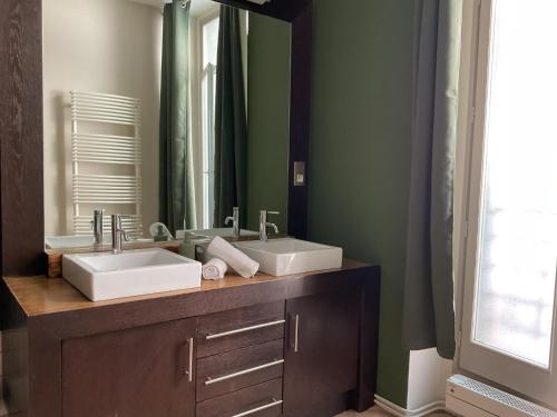a bathroom with two sinks and a mirror at Chambres de charme MAMIE ANGELE in Saint-Antonin-Noble-Val