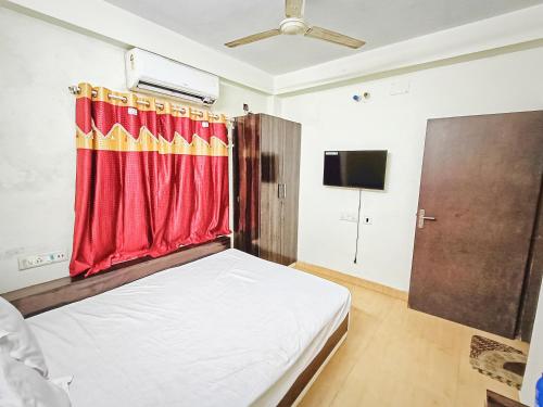 a bedroom with a bed with a red curtain at Rest Inn Hotel Newtown Road Near Tata Medical in Kolkata