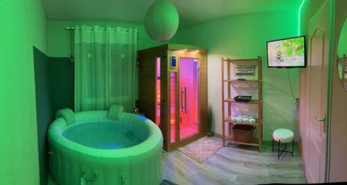 - une salle de bains verte pourvue d'une baignoire dans l'établissement villa familiale avec spa et sauna, à Saint-Antonin-de-Sommaire