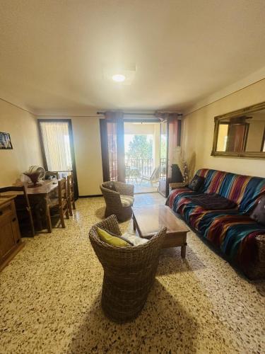 un salon avec un canapé et une table dans l'établissement Studio proche du centre-ville, à LʼÎle-Rousse