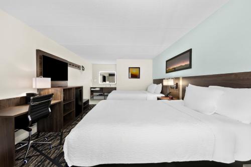 a hotel room with two beds and a desk at Clarion Inn & Suites near the Leconte Center Pigeon Forge in Pigeon Forge