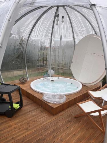 a hot tub in a dome tent with a chair at VILLA PATTY ASSISI con SPA in Assisi