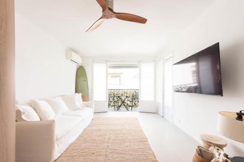 - un salon avec un canapé blanc et un ventilateur de plafond dans l'établissement Bright 1-Br Apartment Walk to the Beach, à Cannes