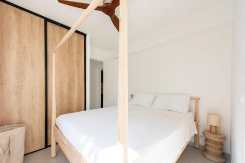 - une chambre avec un lit blanc et un plafond en bois dans l'établissement Bright 1-Br Apartment Walk to the Beach, à Cannes