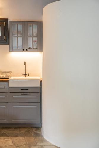 a kitchen with a sink and a white column at Aeolos Hotel & Villas - Pelion in Chorefto