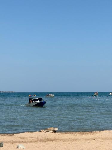 a boat floating in the water near a beach at Алые Паруса in Cholpon-Ata