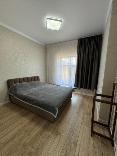 a bedroom with a large bed and a window at Алые Паруса in Cholpon-Ata