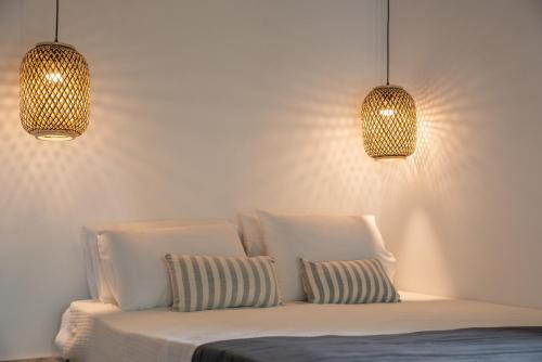 a bed with two pillows and two lights above it at Aeolos Hotel & Villas - Pelion in Chorefto