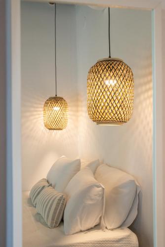 a room with three pillows on a bed with two lights at Aeolos Hotel & Villas - Pelion in Chorefto