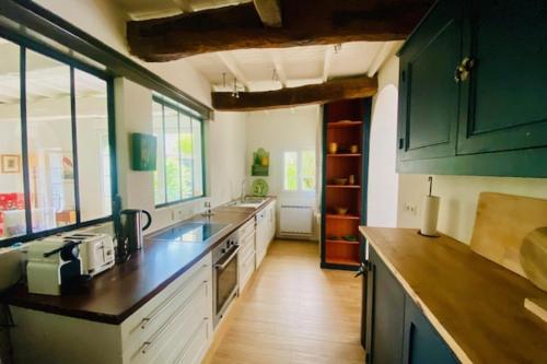 une cuisine avec des placards verts et un comptoir dans l'établissement Charming house near Ile de Ré with terrace, à Nieul-sur-Mer