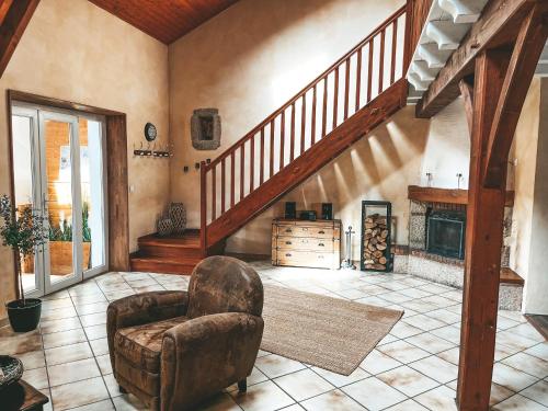 a living room with a staircase and a chair at Villa de Charme en Haute-Savoie in Clarafond