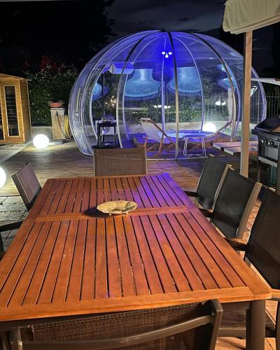 a wooden table with chairs and a igloo in the background at VILLA PATTY ASSISI con SPA in Assisi