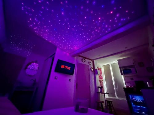 une chambre avec un plafond violet et un panneau indiquant la chance dans l'établissement Romantic Room - Balnéo - Ciel Etoilé - Free Wifi - Netflix - Hyper Centre, à Pézenas