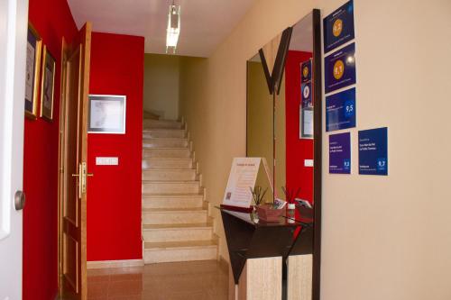 a hallway with a red door and stairs with red walls at Casa Nuri de Rei La Pobla Tornesa in Puebla Tornesa