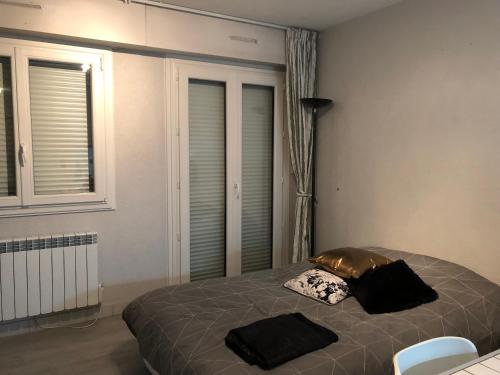 une chambre avec un lit avec deux oreillers dessus dans l'établissement LE CLOS du LAC STUDIO TERRASSE JARDIN et cave Vélos fermée RDC, à Annecy