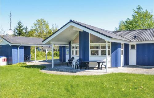 una casa azul con una mesa de picnic en un patio en Three-Bedroom Holiday Home In Orsted, en Ørsted