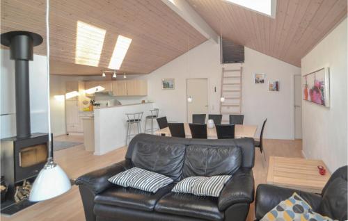 Una sala de estar con un sofá de cuero y una mesa. en Three-Bedroom Holiday Home In Orsted, en Ørsted