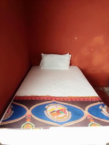 a bed in a red room with a white pillow at Aeropark Dormitories B&B in Maputo