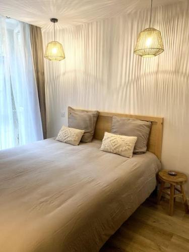 una camera da letto con un letto grande con due cuscini di Refuge Bohème au coeur du Jura a Morez