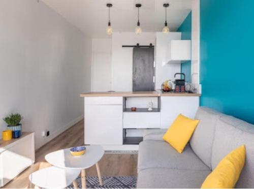 un salon avec un canapé et une table dans l'établissement Cocon design et cosy à La Défense, vue imprenable sur Paris, à Puteaux