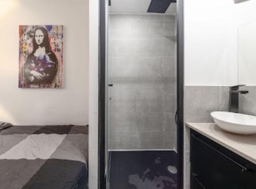 een badkamer met douche en wastafel bij Cocon design et cosy à La Défense, vue imprenable sur Paris in Puteaux