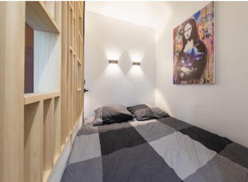 een slaapkamer met een bed met een schilderij aan de muur bij Cocon design et cosy à La Défense, vue imprenable sur Paris in Puteaux