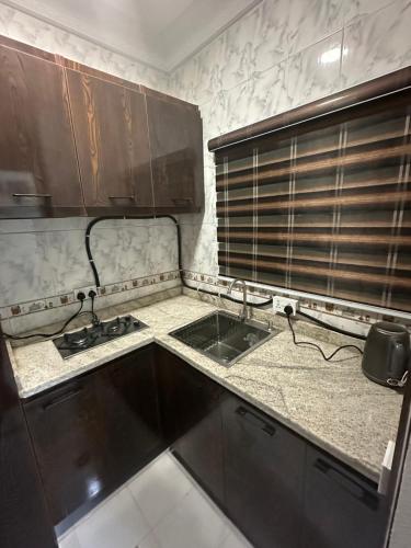 a kitchen with wooden cabinets and a sink at Lesley and Lindsey luxurious short let in Gwarinpa