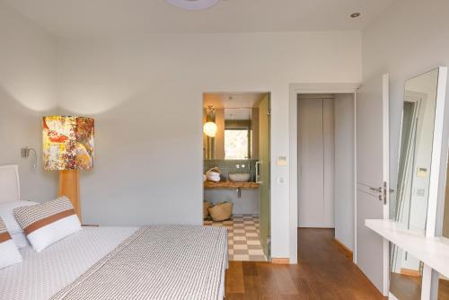 a white bedroom with a bed and a bathroom at Braunis Horio Villas in Asos