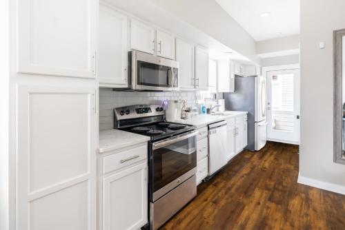 una cucina con mobili bianchi e un forno a piano cottura di Luxury Downtown Townhome Private Garage Unit 16 a Cleveland