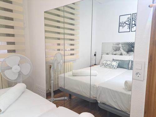 a bedroom with two beds and a mirror at Casa Ángel Ayuntamiento Centro in Logroño