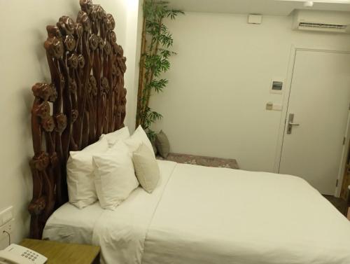 a bedroom with a large bed with white sheets and pillows at Mai Hotel in Hanoi